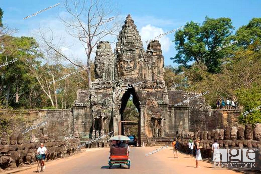 Stock Photo: Tourists at the South gate of a temple, Angkor Thom, Angkor, Siem Reap, Cambodia.