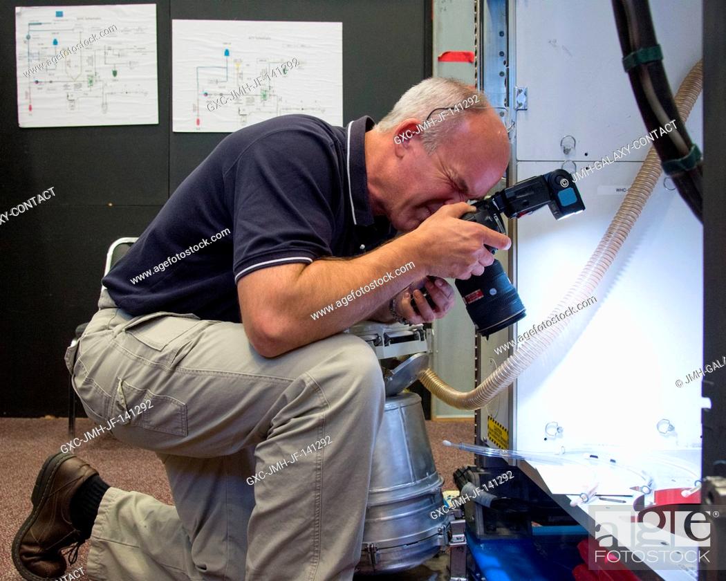 Stock Photo: NASA astronaut Jeff Williams, Expedition 47 flight engineer and Expedition 48 commander, uses a still camera during a routine operations training session in an.