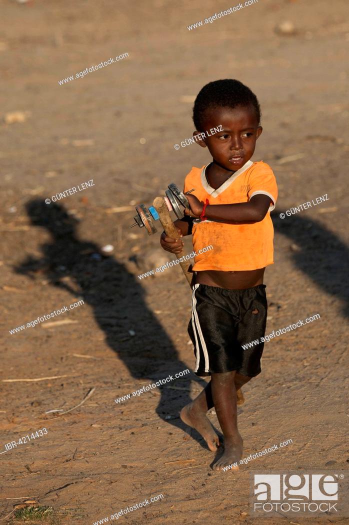 Stock Photo: Boy, 3 years old, with a toy made of cans, Morondava, Madagascar.