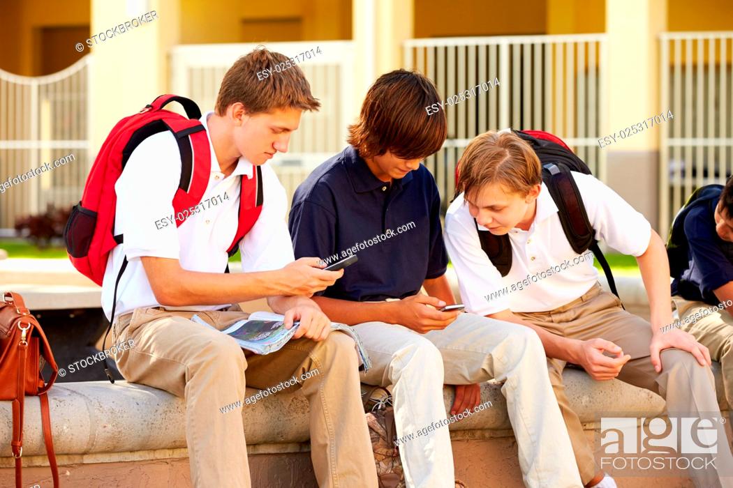 Stock Photo: Male High School Students Using Mobile Phones On School Campus.