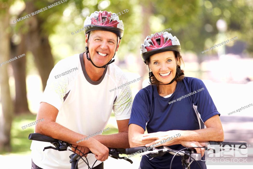 Stock Photo: Portrait Of Mature Couple On Cycle Ride Through Park.