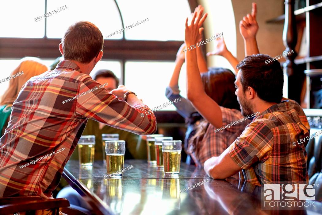Stock Photo: sport, people, leisure, friendship and entertainment concept - happy football fans or friends drinking beer and celebrating victory at bar or pub.