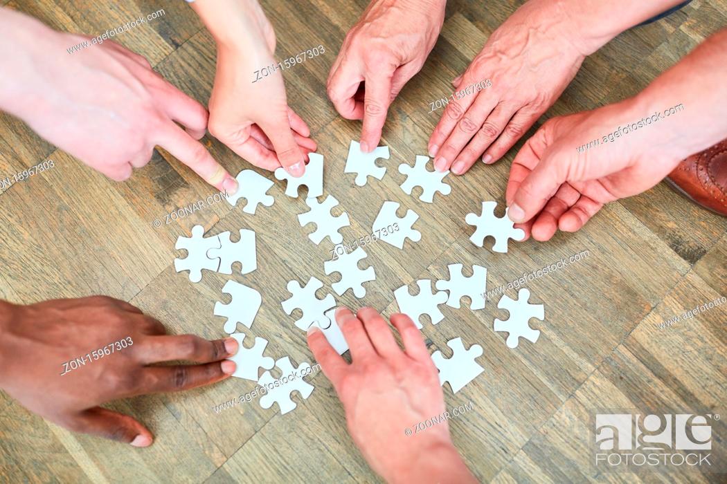 Stock Photo: Hände von Leuten mit vielen Puzzleteilen als Konzept für Beschäftigungstherapie.