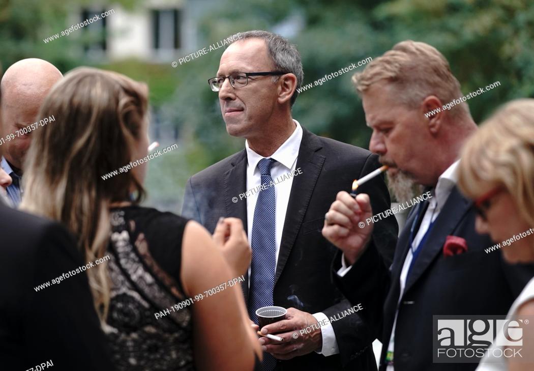 Stock Photo: 01 September 2019, Saxony, Dresden: Jörg Urban (M), top candidate of the AfD, smokes a cigarette before a TV round in the ZDF studio after the announcement of.