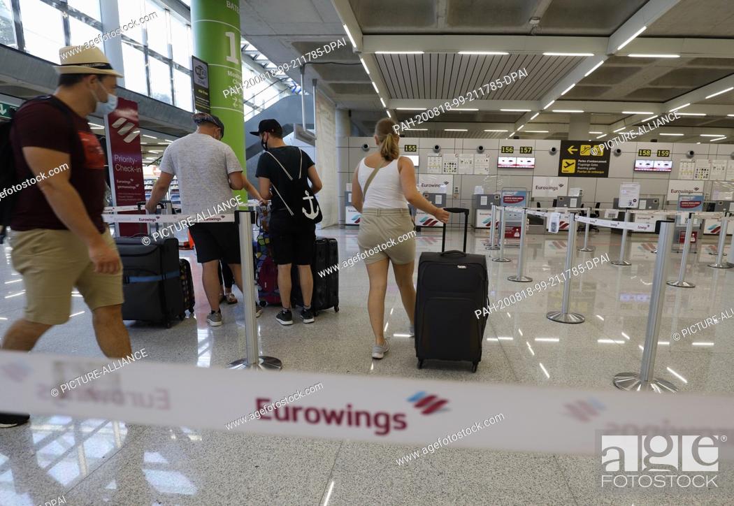 Stock Photo: 18 August 2020, Spain, Palma: Passengers will find the Eurowings check-in desk at Palma de Mallorca airport. On Friday, the German Foreign Office had issued a.