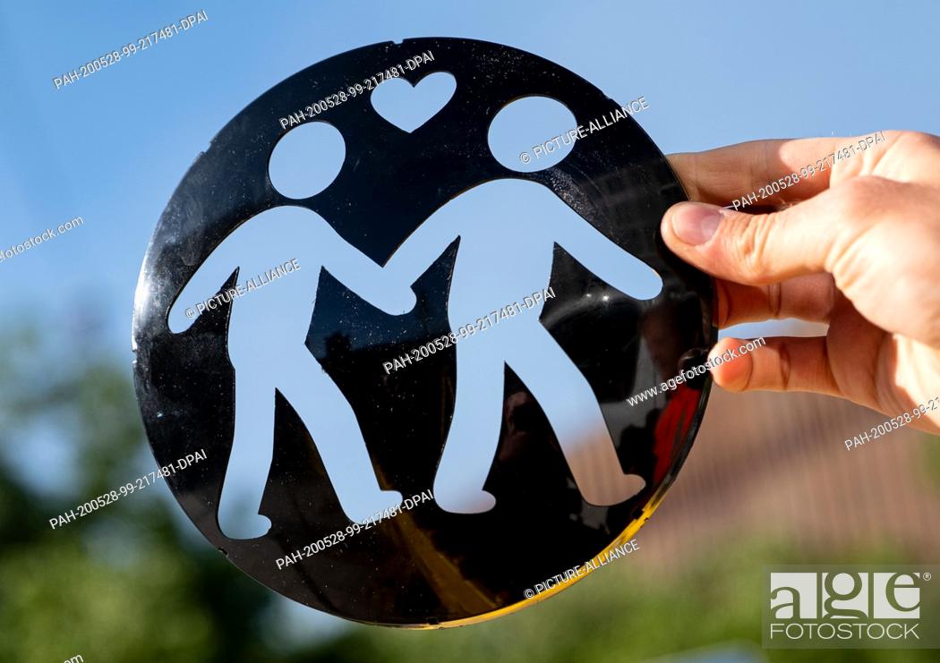 Stock Photo: 28 May 2020, Lower Saxony, Hanover: A signalling disc showing a pair of men is ready for installation at four traffic lights in the city centre of Hanover.