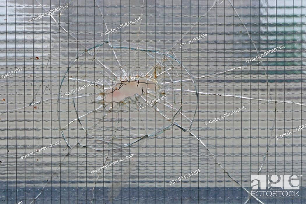 Stock Photo: Cracked safety tempered glass with big hole.