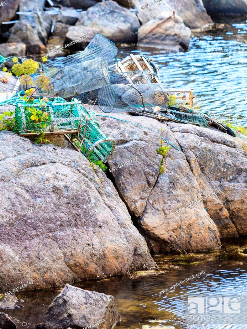 Stock Photo: Fish trap cages for trapping aquqtic animals crabs in port on sea stone shore.