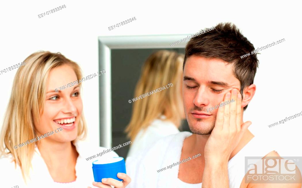 Stock Photo: Man putting cream on his face with her wife.