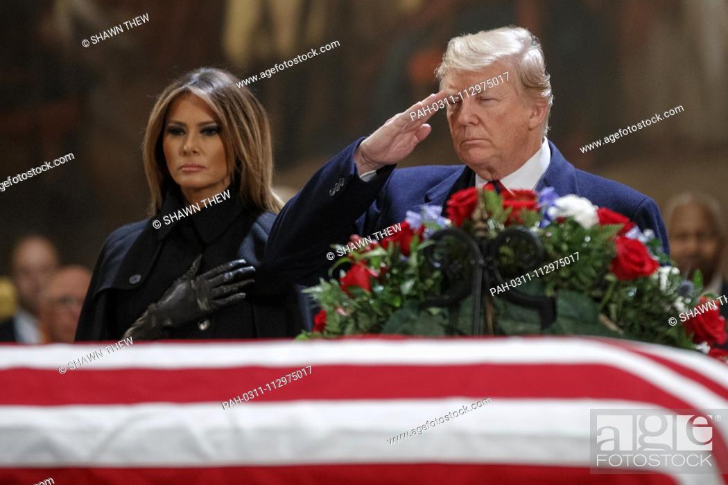 Stock Photo: US President Donald J. Trump, with First Lady Melania Trump, salutes the casket containing the body of former US President George H.W.