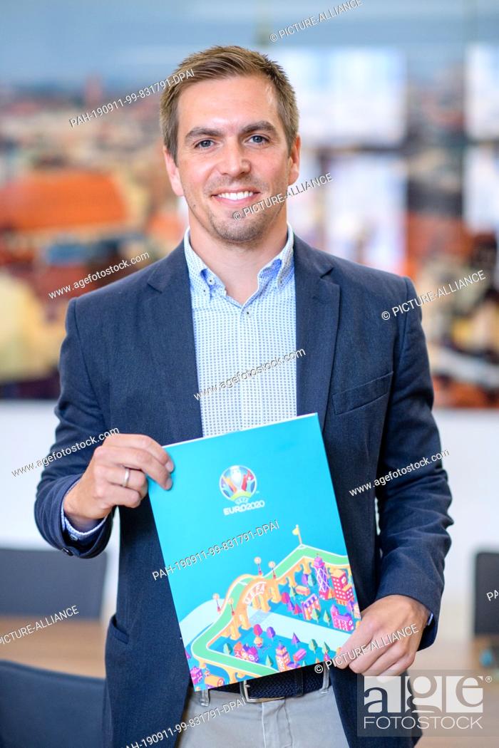 Stock Photo: 11 September 2019, Bavaria, Munich: Philipp Lahm, former professional football player, is holding a UEFA Euro 2020 portfolio in the office of Lord Mayor Reiter.