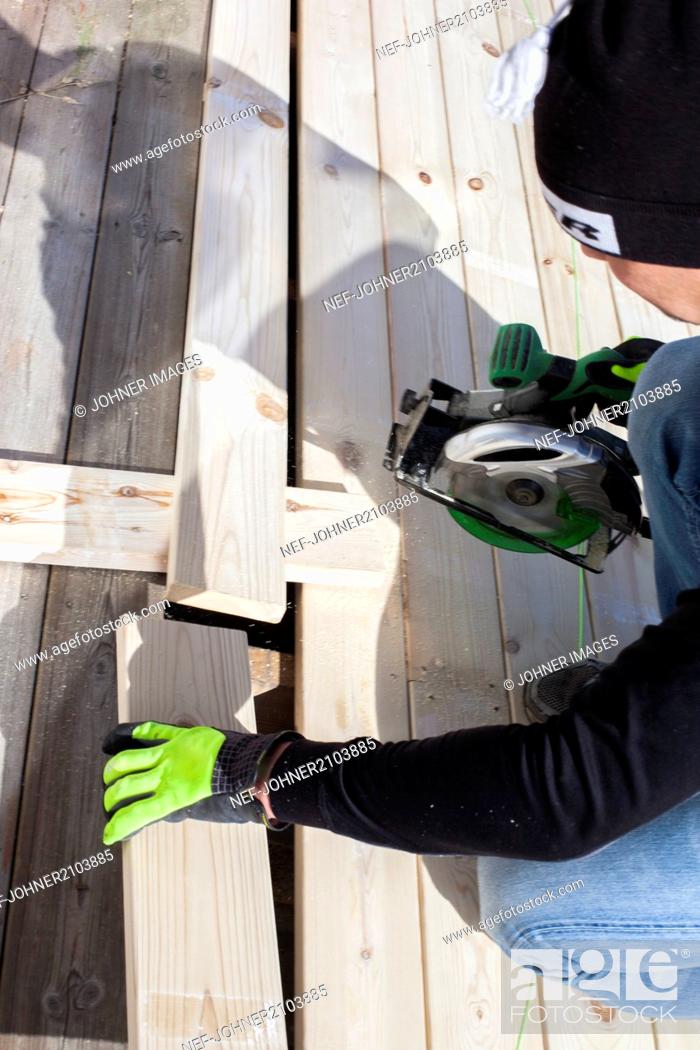 Stock Photo: Man cutting plank.