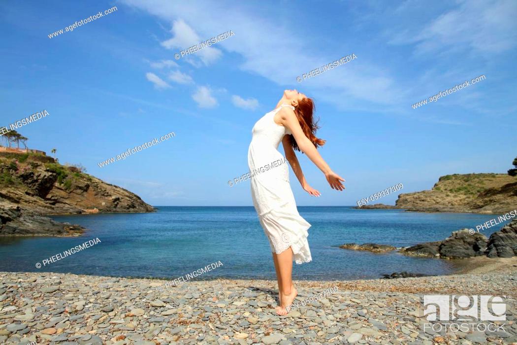 Stock Photo: Woman in white dress breathing fresh air on the beach.