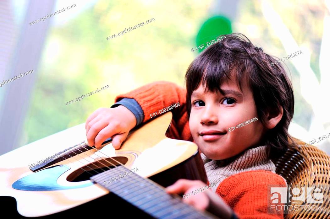 Stock Photo: Kid playing guitar at home.