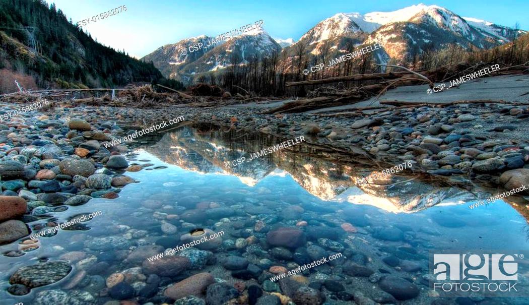 Stock Photo: Mountain Reflection in Still River Side Pool.