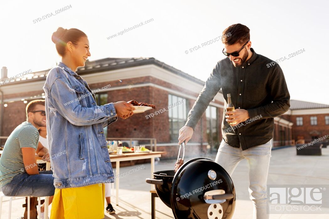 Stock Photo: friends cooking meat on bbq at rooftop party.