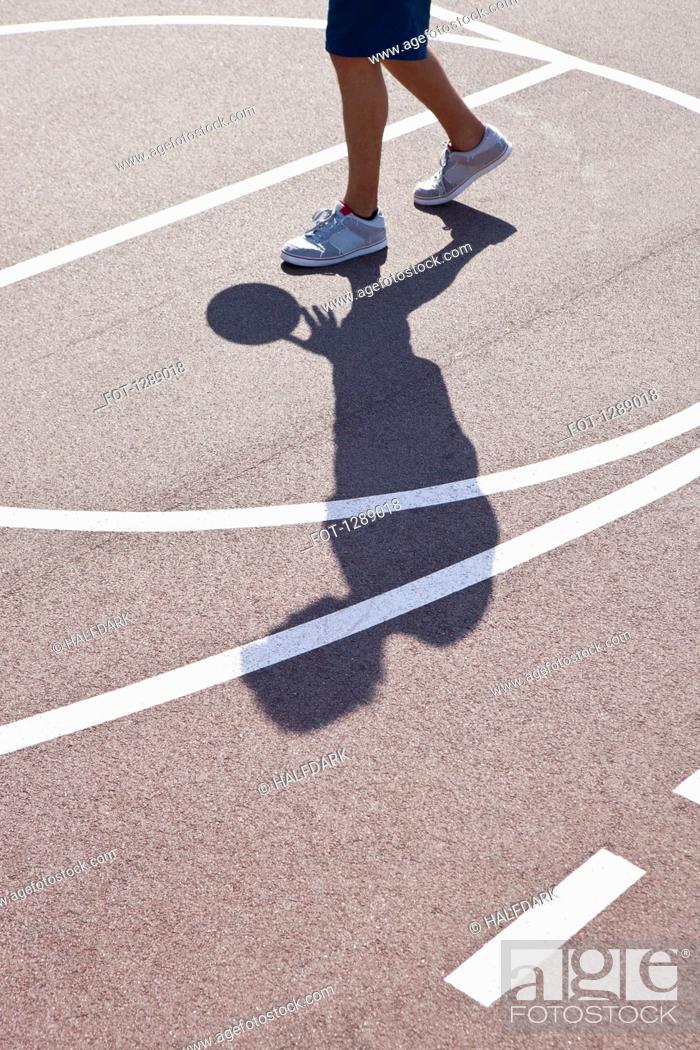 Stock Photo: Man playing basketball, low section.