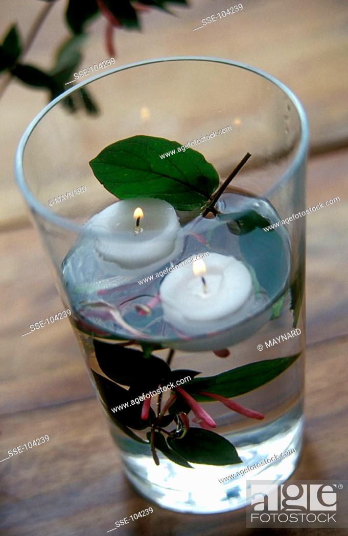 Stock Photo: candles in glass of water.