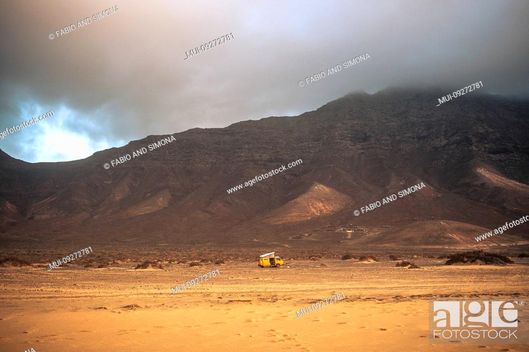 Stock Photo: Wild and free lonely camping with old vintage scenic yellow van parked alone with beach in forehand and mountains with clouds in backgorund - travel concept.