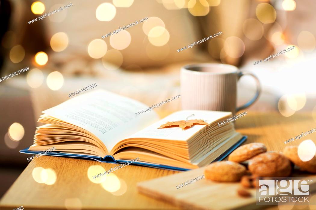 Stock Photo: book with autumn leaf, cookies and tea on table.
