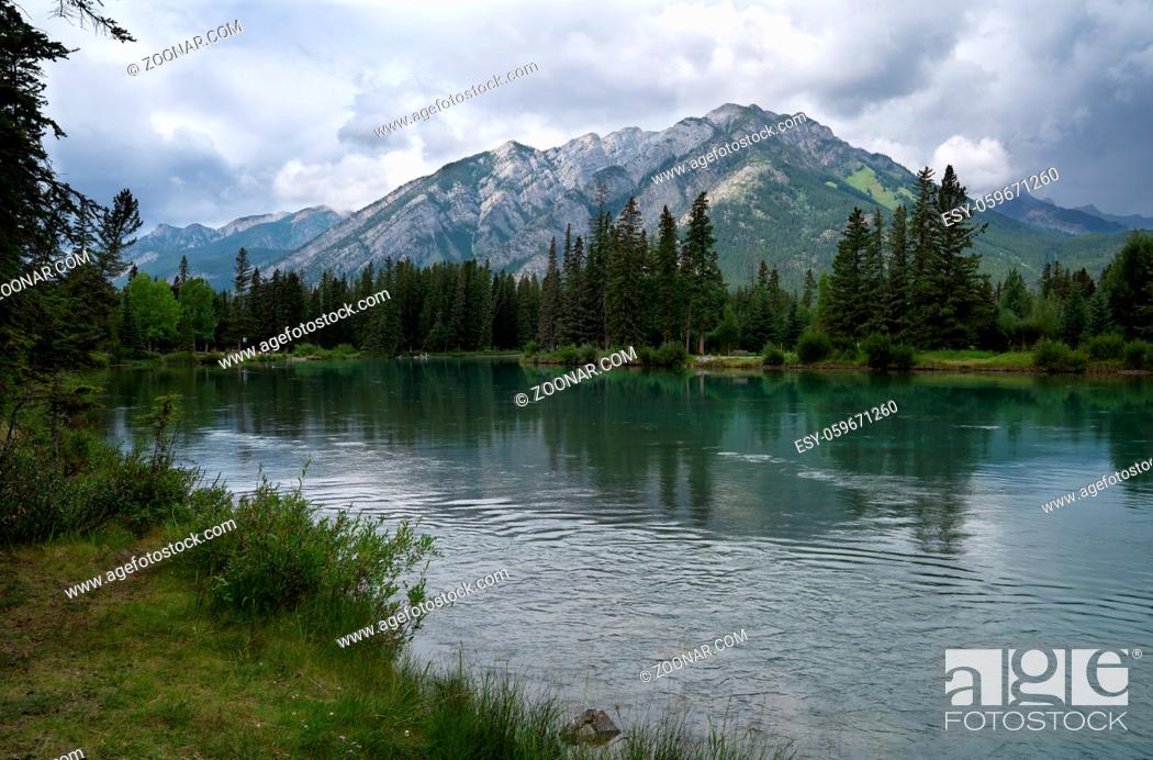 Stock Photo: Panoramic image of the tranquil Bow river close to Banff with cloudy sky, Banff National Park, Alberta, Canada.
