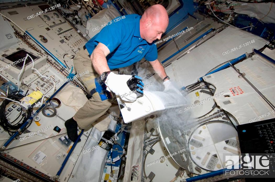 Stock Photo: European Space Agency astronaut Andre Kuipers, Expedition 30 flight engineer, prepares to insert ESA Role of Apoptosis in Lymphocyte Depression 2 (ROALD-2).