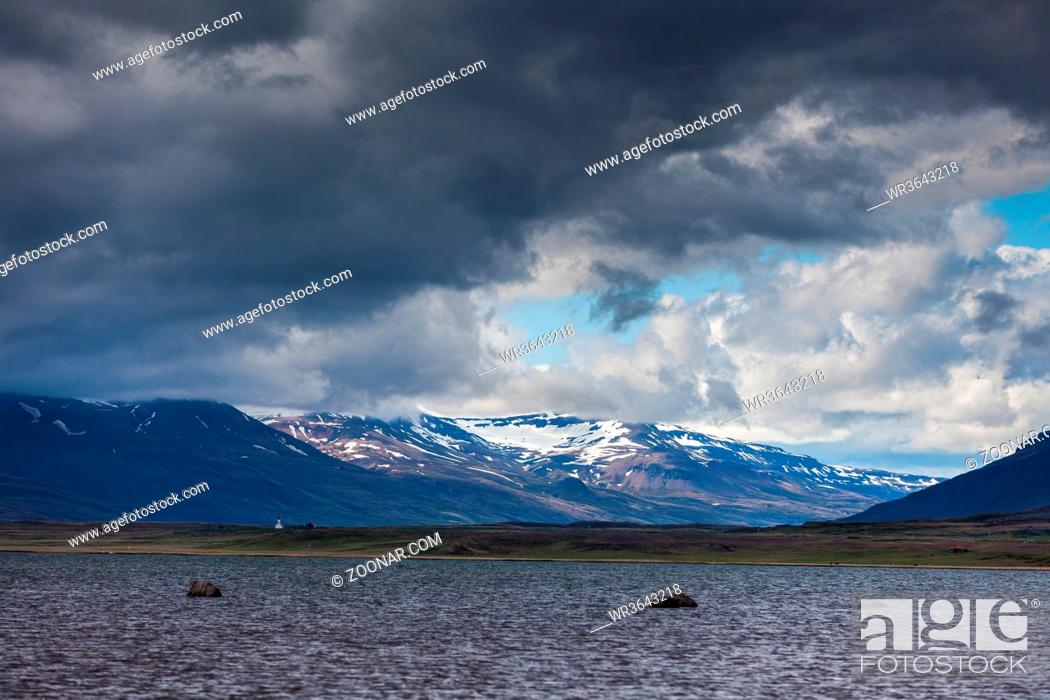 Stock Photo: calm lake with mountains in the background and a cloudy sky on Iceland.