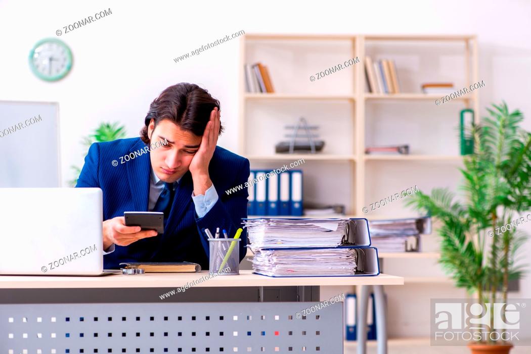 Stock Photo: Young businessman sitting and working in the office.