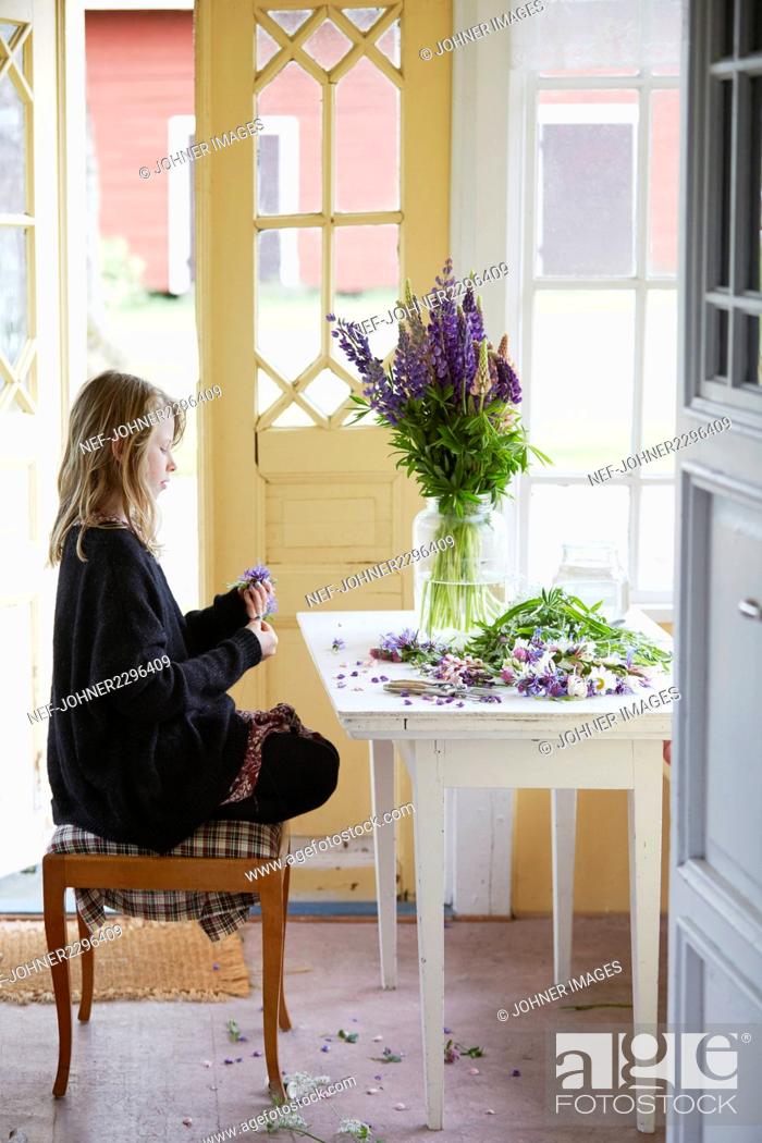 Stock Photo: Girl sitting with flowers.