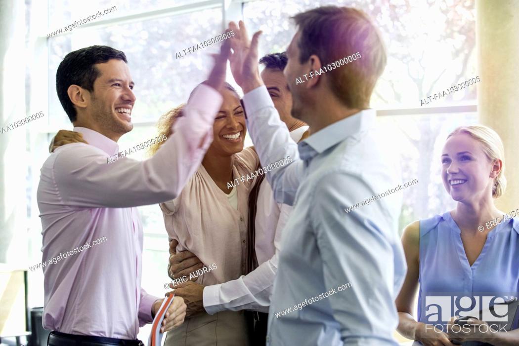 Stock Photo: Colleagues giving each other high-five.