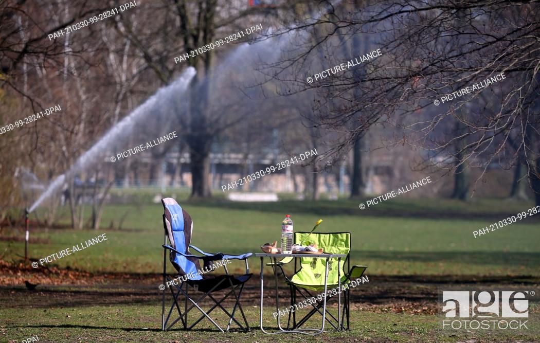 Stock Photo: 30 March 2021, Berlin: A stranger has secured himself a sunny spot in the Tiergarten at temperatures around 18 degrees Celsius.