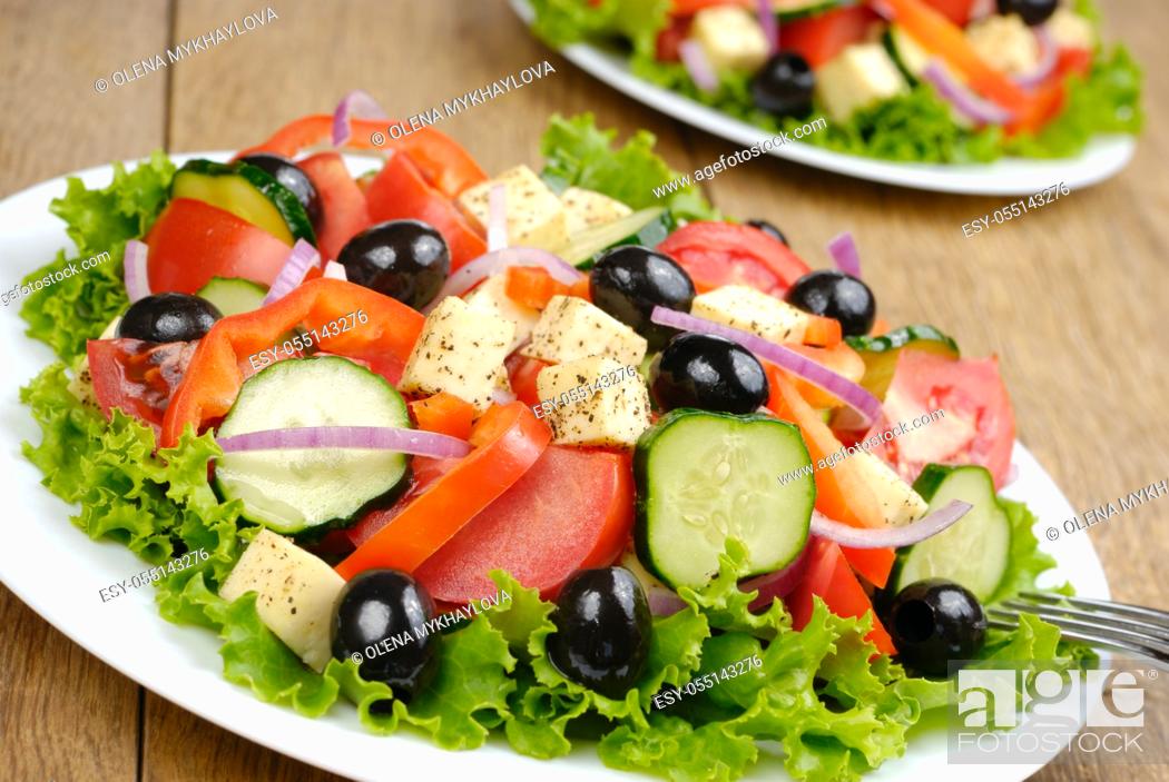 Stock Photo: Greek salad in the white plate on the kitchen table.