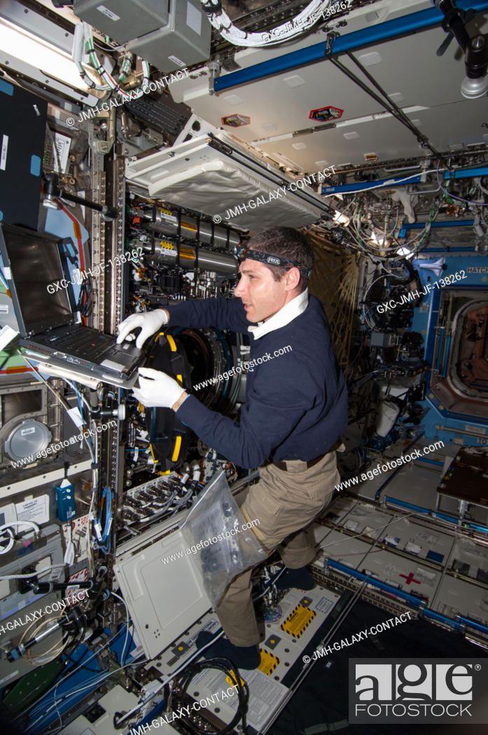 Stock Photo: NASA astronaut Mike Hopkins, Expedition 38 flight engineer, performs in-flight maintenance on combustion research hardware in the Destiny laboratory of the.