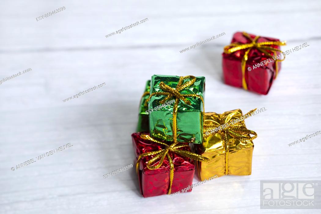 Stock Photo: Pile of colored shiny gift boxes with copy space on white wood background, modern retro Christmas design, Colorful presents, Holiday concept space for text.