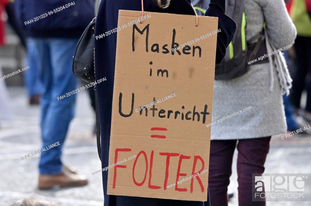 Stock Photo: 23 October 2020, Bavaria, Munich: With posters with the inscription ""Masks in class - torture"" several hundred people demonstrate at Odeonsplatz against the.