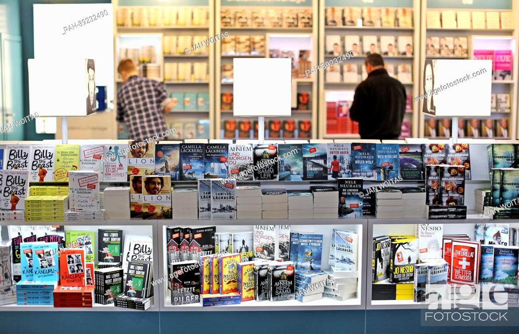 Stock Photo: Two men arrange books at the exhibition booth of the Ullstein publishing house prior to the opening of the book fair in Leipzig,  Germany, 22 March 2017.