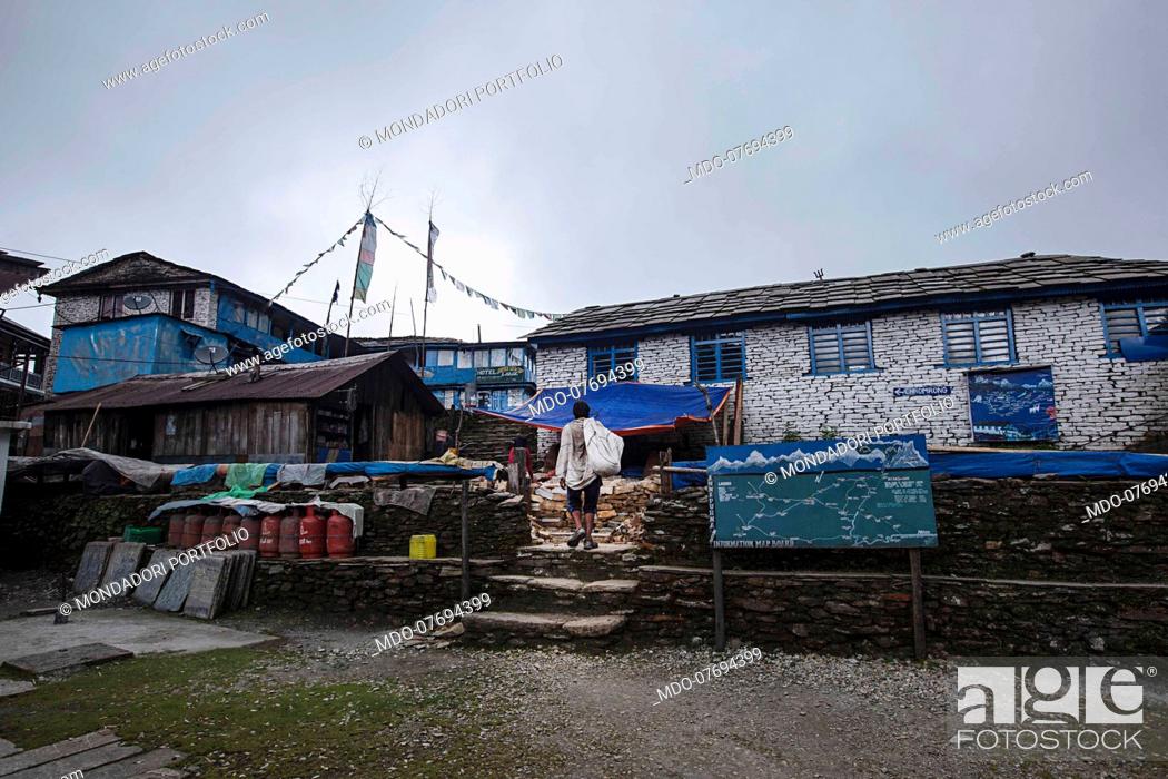 Stock Photo: A man walking in a Village. Annapurna Conservation Area (Nepal), August 23rd 2019.