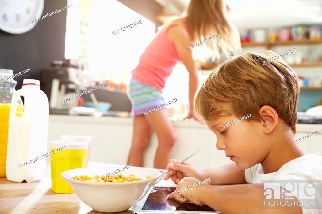 Stock Photo: Children Eating Breakfast And Playing With Digital Tablet.