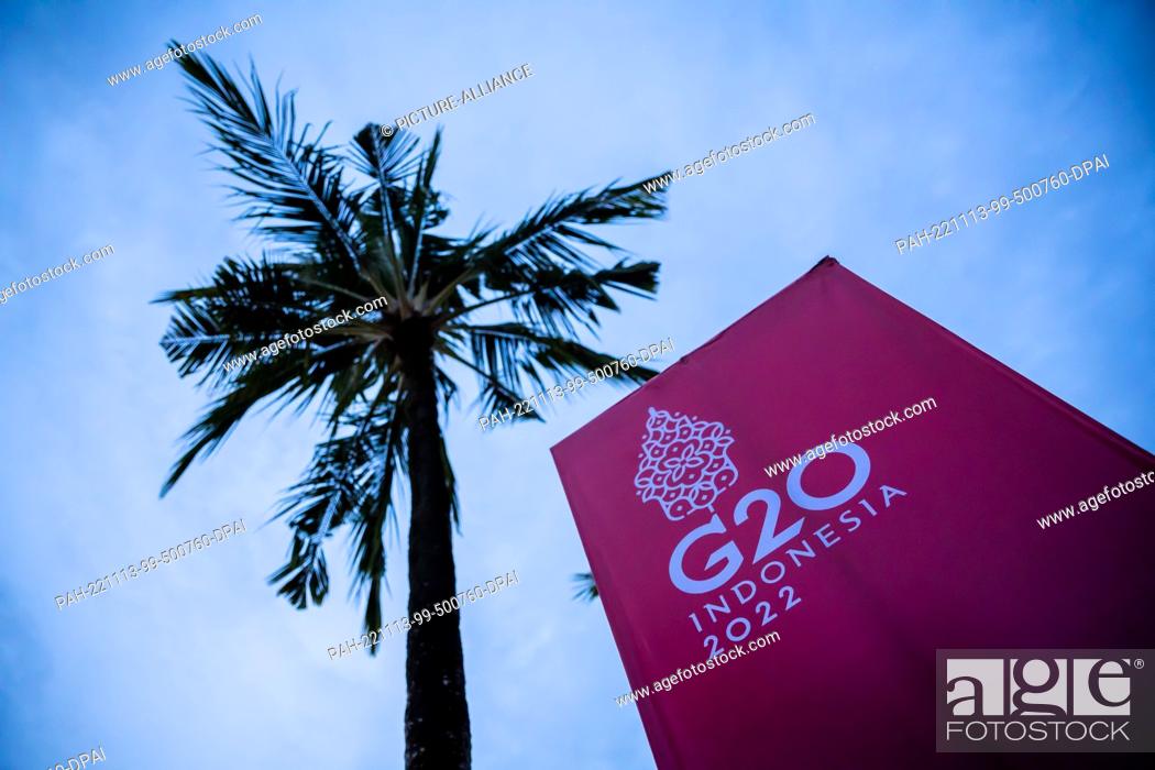 Stock Photo: 13 November 2022, Indonesia, Nusa Dua: A palm tree next to a banner of the G20 summit. The meeting of the G20 group, the strongest industrialized nations and.