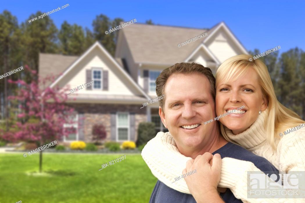 Stock Photo: Happy couple hugging in front of beautiful house.