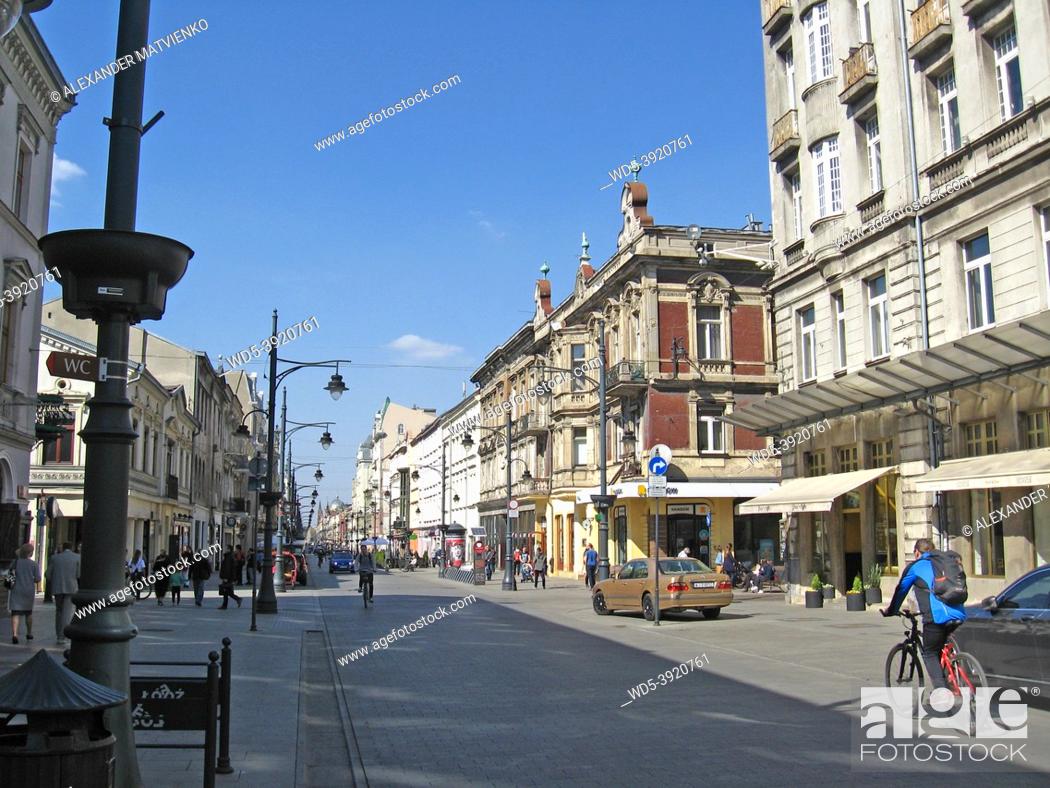 Stock Photo: View of city street with biker in hot summer day. People riding bicycles. City life. Central street of Lodz Piotrkowska street.
