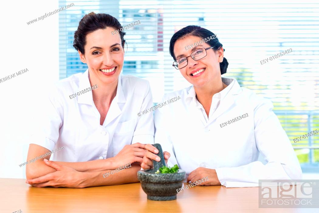 Stock Photo: Scientists mixing herbs with pestle and mortar.
