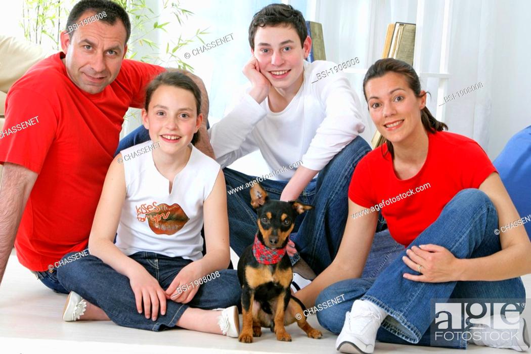 Stock Photo: Models. Brother and sister aged respectively 16-year-old and 8-year-old with their parents. The dog is cross bred Pinscher-Jack Russell with a tatoo.
