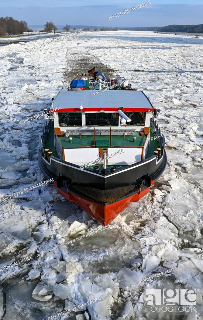 Stock Photo: 18 February 2021, Brandenburg, Schwedt: A German icebreaker sails on the German-Polish border river Oder. Drift ice is increasing the risk of flooding in some.
