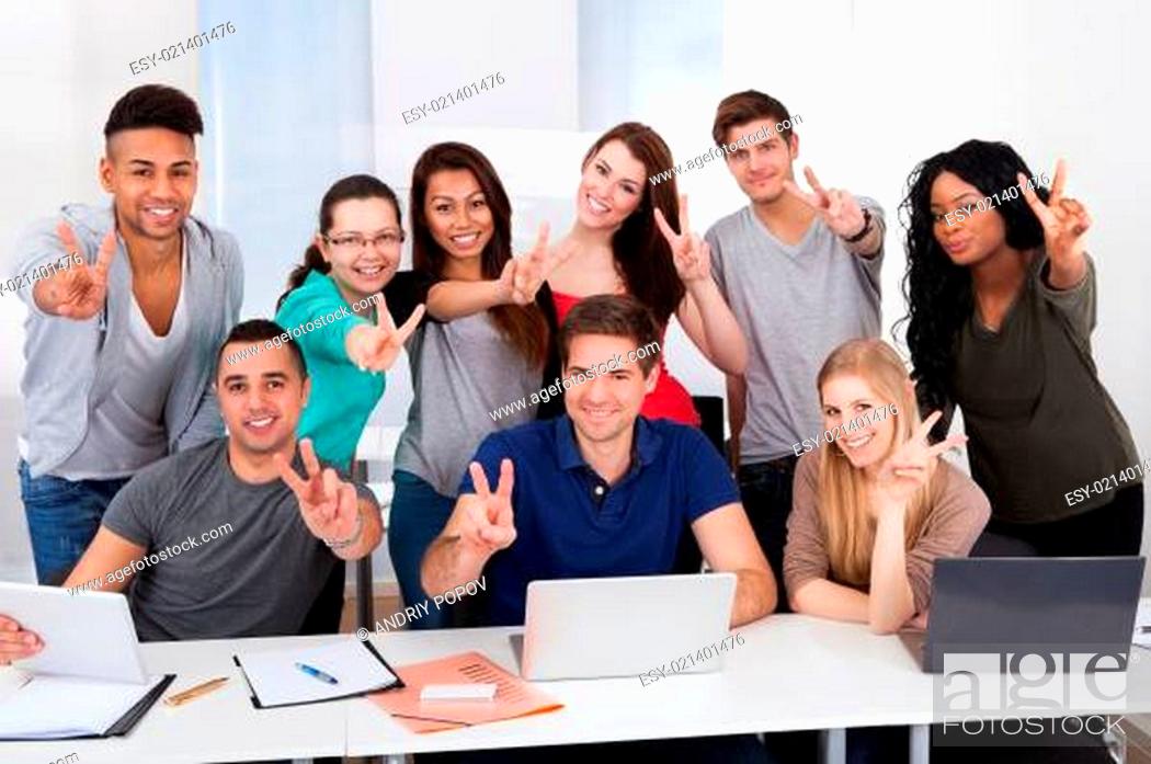 Stock Photo: College Students Gesturing Victory Sign Together.