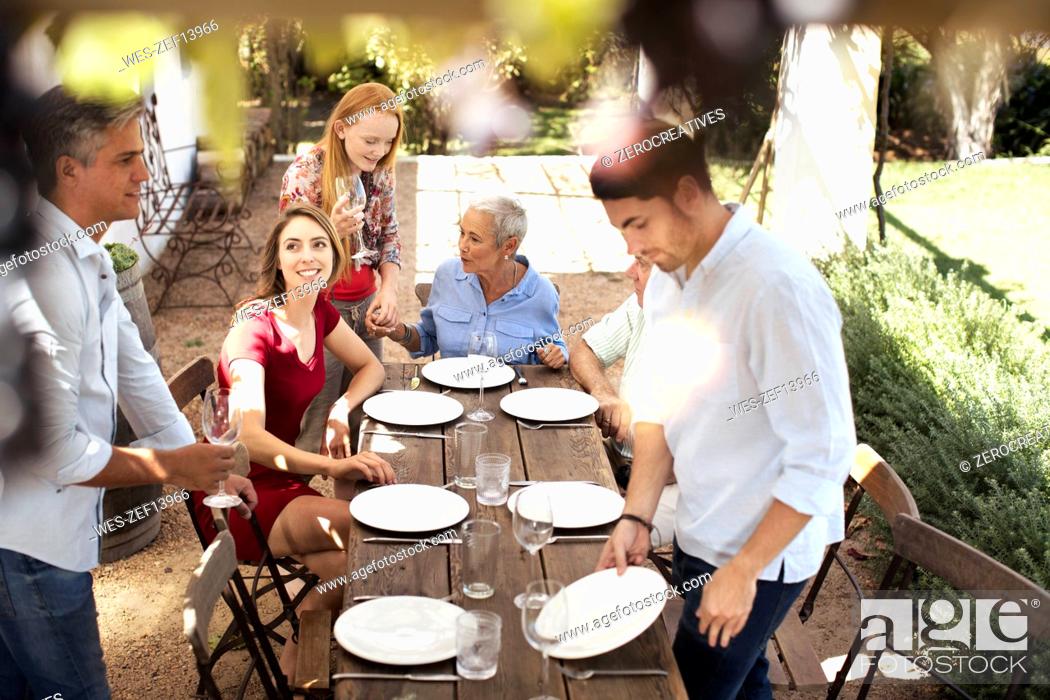 Stock Photo: Family setting table outside for lunch.