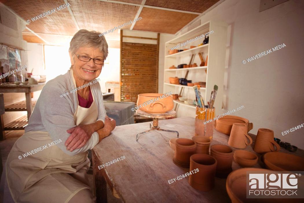 Stock Photo: Portrait of female potter sitting at table.