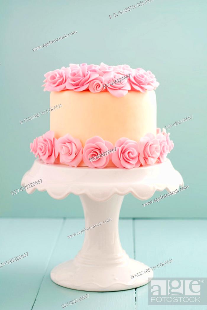 Stock Photo: Ivory fondant covered cake with pink sugar roses on cake stand.