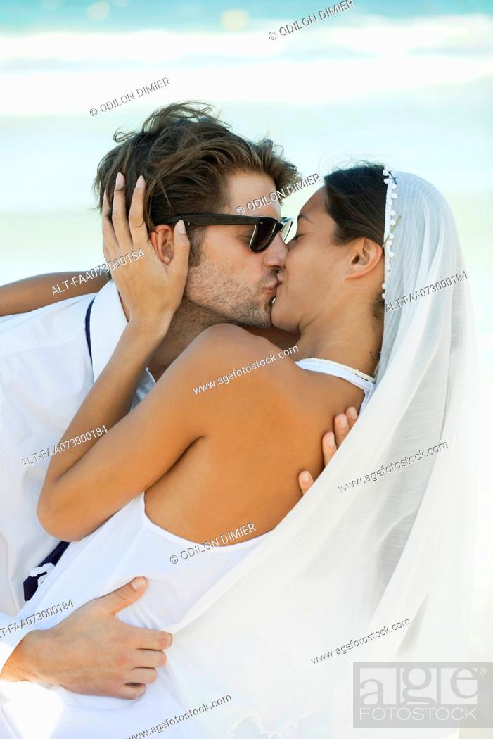 Photo de stock: Bride and groom kissing at the beach.