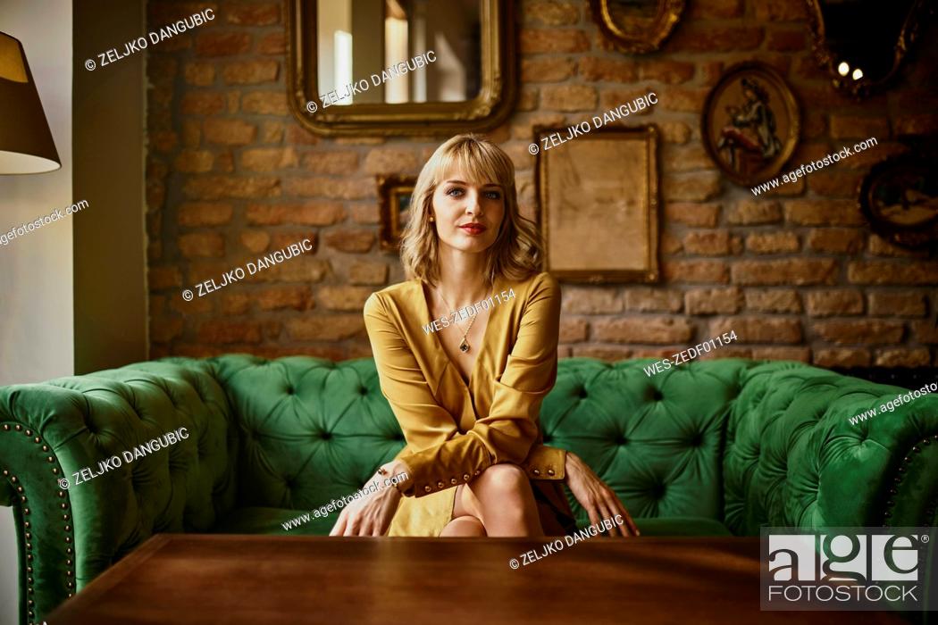 Stock Photo: Portrait of elegant woman sitting on a couch.